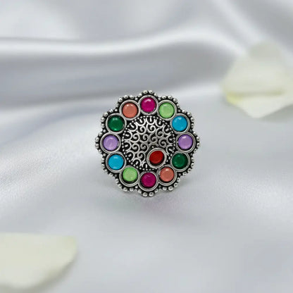 Multicolored gemstone ring on a white fabric background