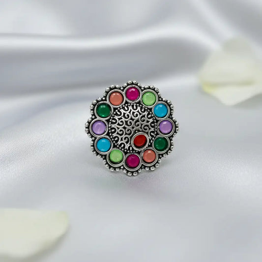Multicolored gemstone ring on a white fabric background