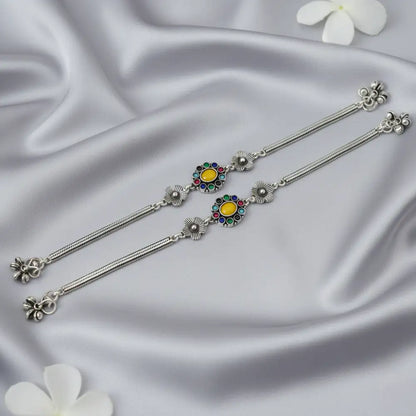 Silver earrings with colorful gemstones on a satin background