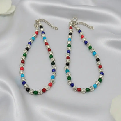 Two colorful beaded necklaces on a satin surface