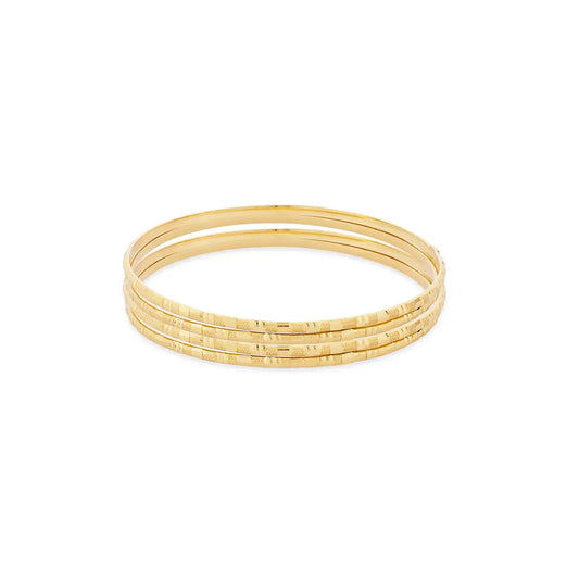 Set of gold bangles on a white background