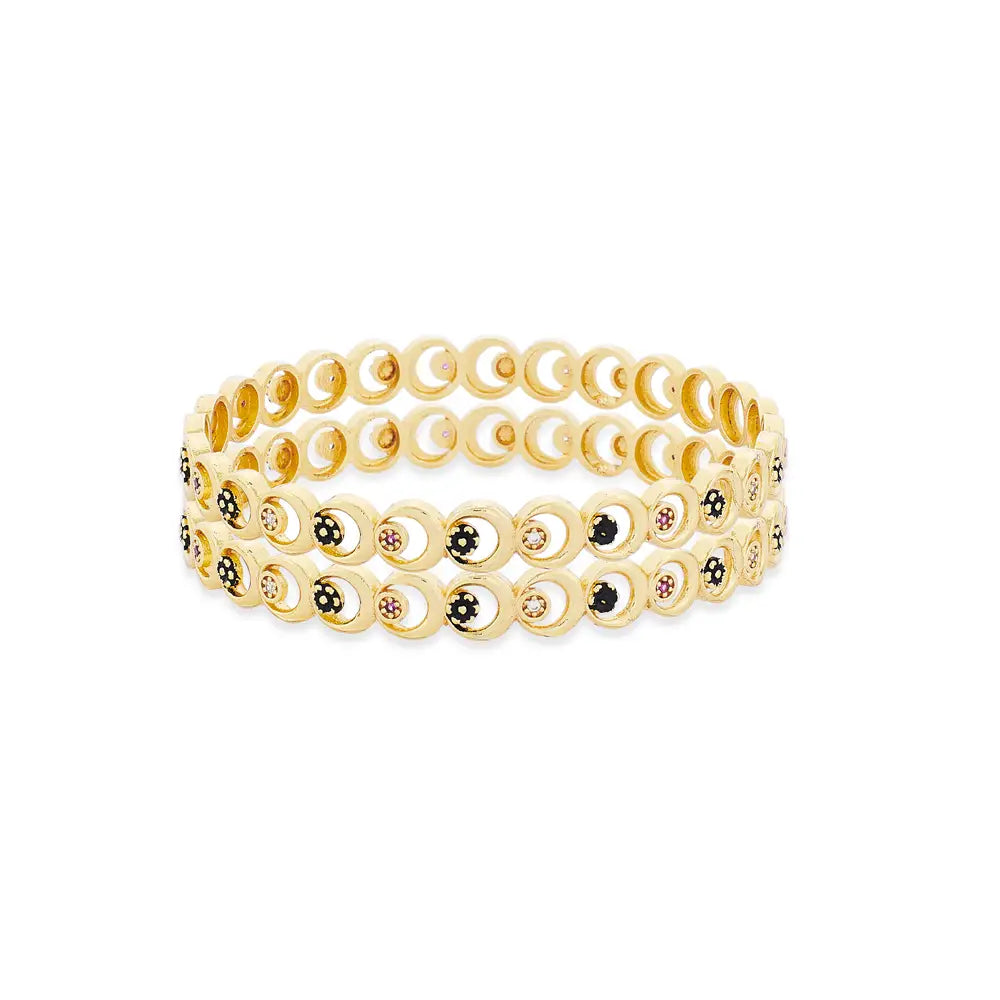 Set of gold bangles with small stones on a white background