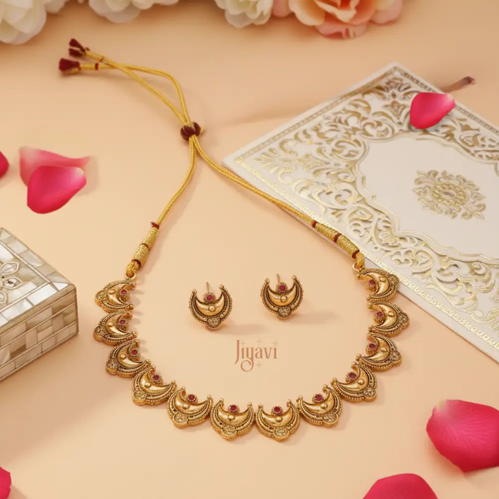 Gold necklace and earrings set with 'Jiyavi' branding on a decorative background.