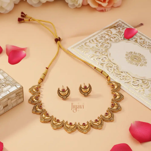 Gold necklace and earrings set with 'Jiyavi' branding on a decorative background.