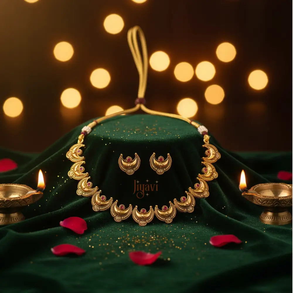 Gold necklace and earrings on a green fabric with 'Jiyavi' branding, surrounded by Diwali decorations.