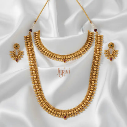 Gold necklace and earrings set on a white fabric background with 'Jiyavi' branding.