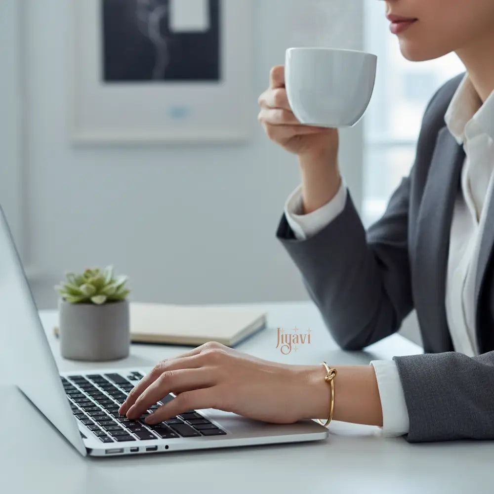working woman on laptop wearing formals and knot design bracelet in hand