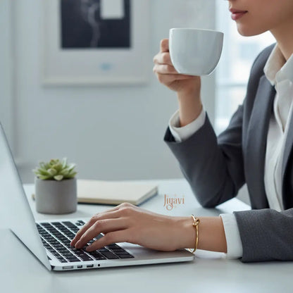 working woman on laptop wearing formals and knot design bracelet in hand