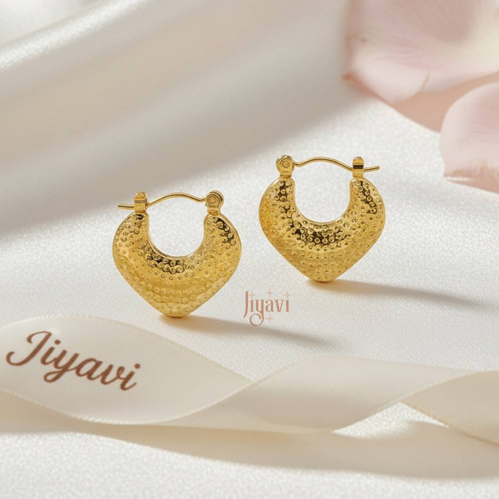 Gold hoop earrings on a soft fabric background with 'Jiyavi' branding.