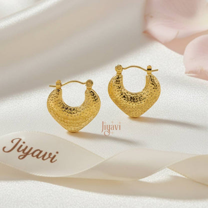 Gold hoop earrings on a soft fabric background with 'Jiyavi' branding.