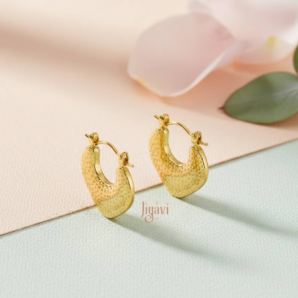 Gold hoop earrings on a soft pastel background with 'Jiyavi' branding.