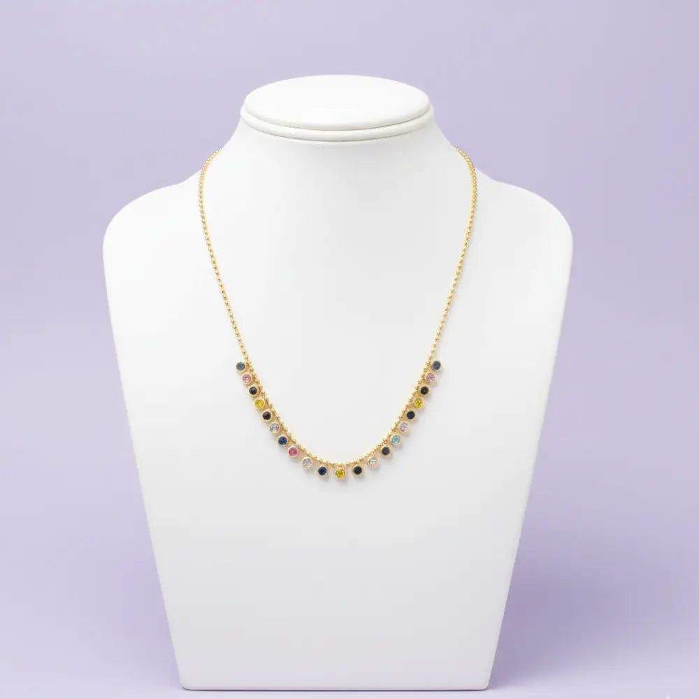 Necklace on a mannequin bust against a light purple background
