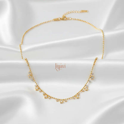 Gold necklace with small pearls on a white satin background, featuring the brand 'liyavi'.