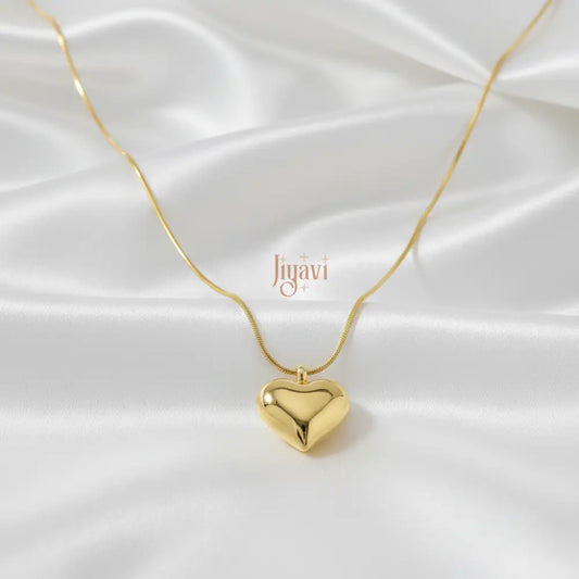 Gold heart-shaped pendant necklace on a white satin background with 'Jovani' branding.