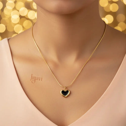 Gold necklace with a heart pendant on a model against a blurred golden background
